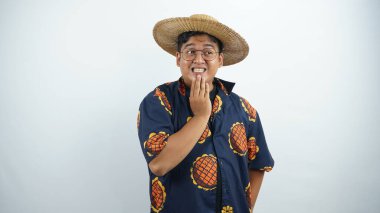 Asyalı adam şaşırmış bir ifadeyle geleneksel şapka takıyor, güneş gözlüğü ve şapka takıyor..