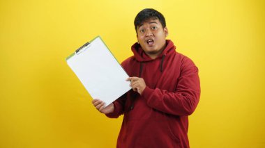 Sarı arkaplanda yeşil klasör taşıyan Asyalı adamın portresi