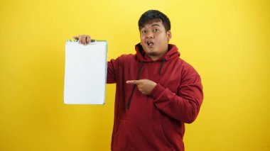 Asyalı adam boş beyaz tahtayı tutuyor.