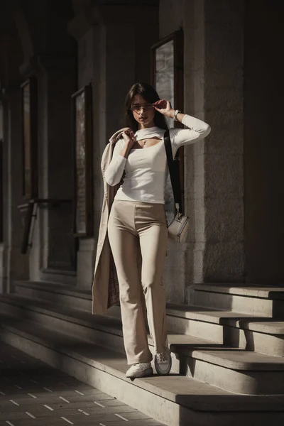 Όμορφη Μελαχρινή Κοπέλα Ντυμένη Λευκή Μπλούζα Παντελόνι Sneakers Τσάντα Και — Φωτογραφία Αρχείου
