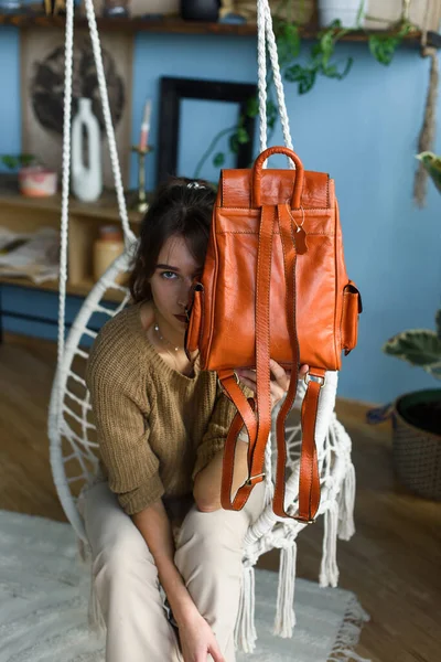 베이지 바지와 올리브 스웨터를 아름다운 소녀가 오렌지 가방을 의자에 포즈를 — 스톡 사진