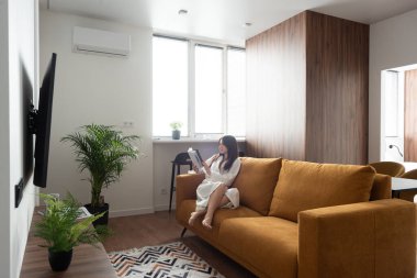 Güzel bir kadın mutfakta dergi okuyor. Tadilattan sonra daire. konut kredisi