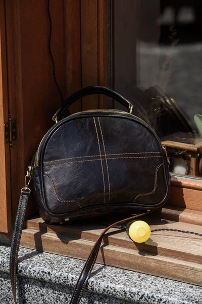 small leather bags, brown colour. round old-fashioned leather bag. outdoors photo.