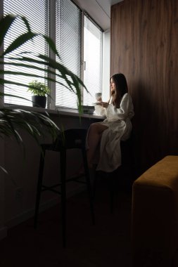 Sabahları evde kahve içen bir kadın. Konforlu evde güzel bir sabah.