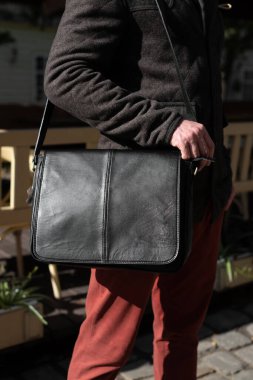 close-up photo of black leather bag. outdoors photo