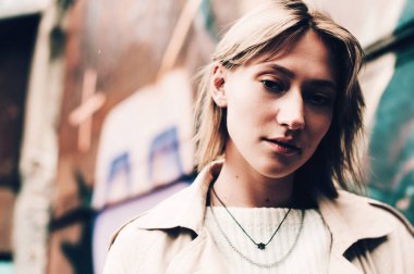 Yakın plan portre güzel zarif kadın bej ceket ve siyah şapka giyiyor. Moda kıyafetleri. Yumuşak seçici odaklanma. tahıl.