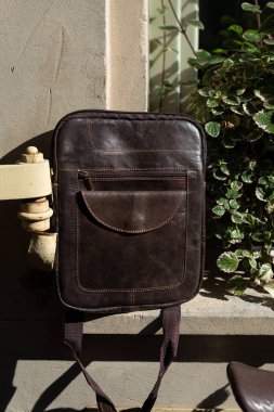 close-up photo of brown messanger leather bag. outdoors photo