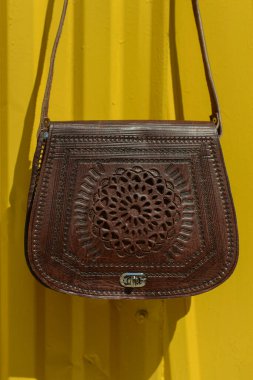 İşlenmiş desenli küçük kahverengi kadın deri çantası. sokak fotoğrafı