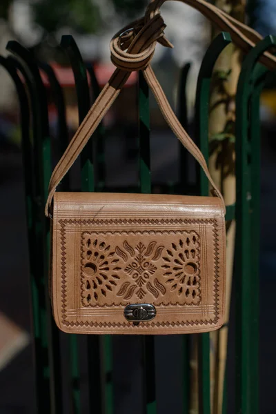 İşlenmiş desenli küçük kahverengi kadın deri çantası. sokak fotoğrafı
