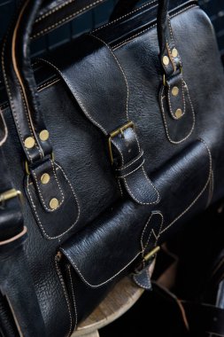 Siyah deri seyahat çantası, siyah arka planda kapalı bir fotoğraf..