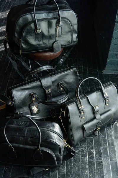 Four Different Size Shape Black Leather Travel Bags Indoors Photo — Stock Photo, Image