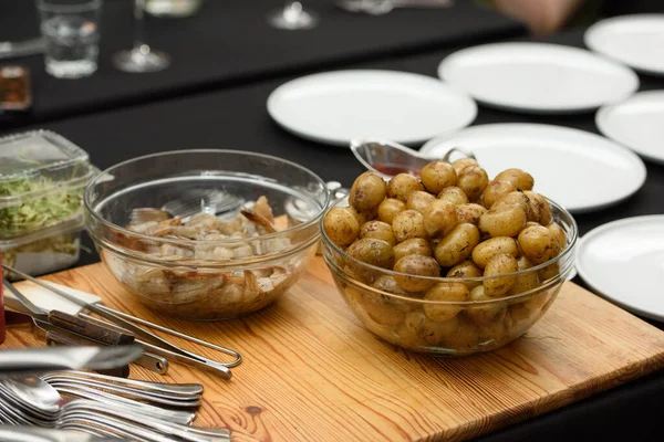 Siyah masa arkasında servis edilen geleneksel İspanyol tapaları. Gambas Ajillo ile Patatas Bravas.