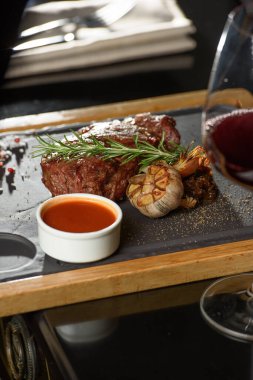 Lezzetli ızgara biftek, kırmızı şarap, baharatlar, taze biberiye ve ızgara sebze..