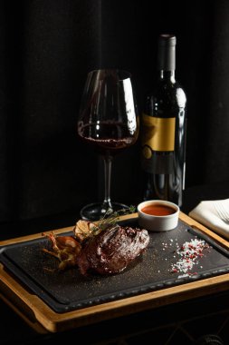 Lezzetli ızgara biftek, kırmızı şarap, baharatlar, taze biberiye ve ızgara sebze..