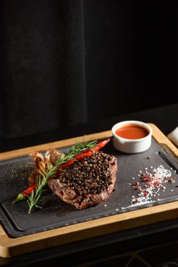 Lezzetli ızgara biftek, kırmızı şarap, baharatlar, taze biberiye ve ızgara sebze..