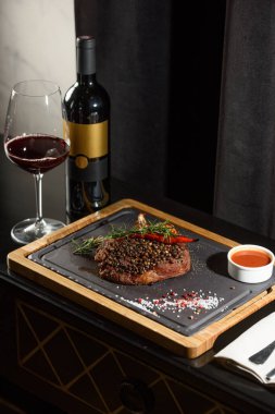 Lezzetli ızgara biftek, kırmızı şarap, baharatlar, taze biberiye ve ızgara sebze..