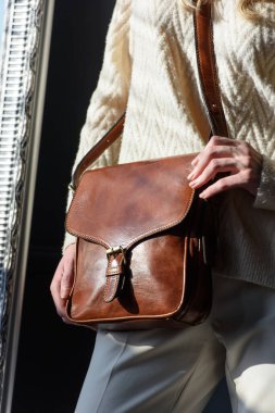 Güzel kıvırcık sarı saçlı kadın küçük kahverengi bir mankenle poz veriyor şık beyaz kazak ve klasik pantolon giyiyor.