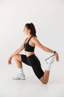 Evde yoga yaparken gülümseyen sağlıklı bir kadın. pilates