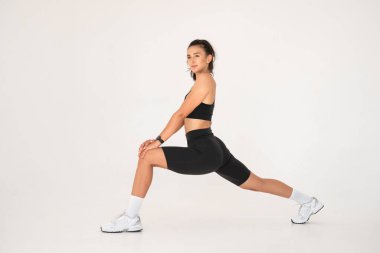 Evde yoga yaparken gülümseyen sağlıklı bir kadın. pilates