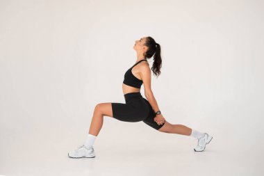 Evde yoga yaparken gülümseyen sağlıklı bir kadın. pilates