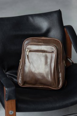 Kahverengi deri sırt çantası şık sandalyede..