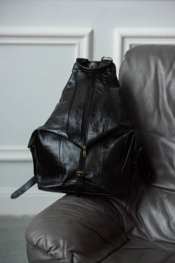 Siyah deri sırt çantası sandalyede, yaklaş...