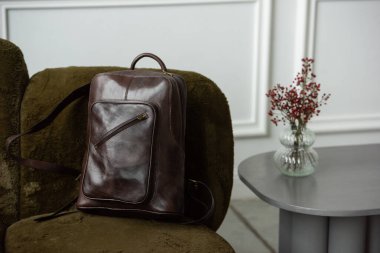 Sandalyede kahverengi deri sırt çantası, yakın çekim..