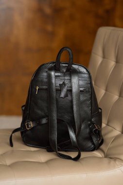 Sandalyede siyah deri bir sırt çantası..