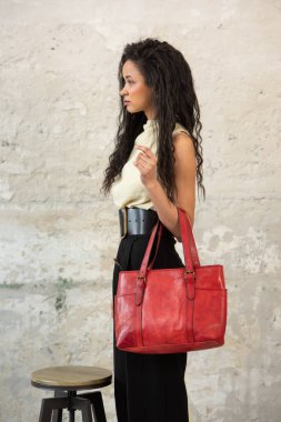 Moda mankeni, canlı kırmızı bir aksesuar ile modern bir kıyafet sergiliyor.