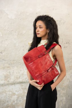 Moda mankeni, canlı kırmızı bir aksesuar ile modern bir kıyafet sergiliyor.