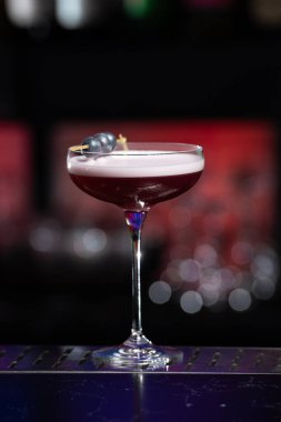 Bulanık arka planda yeşil ve beyaz Bokeh ışıkları ipuçları içeren koyu tonlar var. Bu da şık bir bar ayarına işaret ediyor.