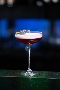 Bulanık arka planda yeşil ve beyaz Bokeh ışıkları ipuçları içeren koyu tonlar var. Bu da şık bir bar ayarına işaret ediyor.