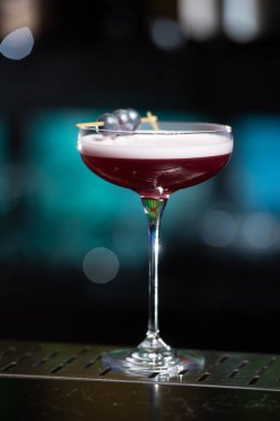 Bulanık arka planda yeşil ve beyaz Bokeh ışıkları ipuçları içeren koyu tonlar var. Bu da şık bir bar ayarına işaret ediyor.