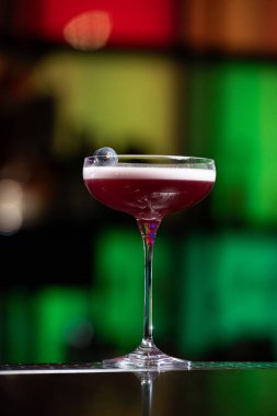 Bulanık arka planda yeşil ve beyaz Bokeh ışıkları ipuçları içeren koyu tonlar var. Bu da şık bir bar ayarına işaret ediyor.