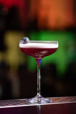 Bulanık arka planda yeşil ve beyaz Bokeh ışıkları ipuçları içeren koyu tonlar var. Bu da şık bir bar ayarına işaret ediyor.