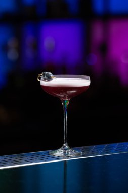 Bulanık arka planda yeşil ve beyaz Bokeh ışıkları ipuçları içeren koyu tonlar var. Bu da şık bir bar ayarına işaret ediyor.