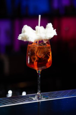 Arka planda koyu mavi ve mor renkli bulanık bir karışım var. Bu da modern bir bar ya da dinlenme odası atmosferi olduğunu gösteriyor.