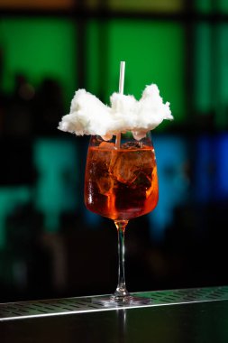 Arka planda koyu mavi ve mor renkli bulanık bir karışım var. Bu da modern bir bar ya da dinlenme odası atmosferi olduğunu gösteriyor.