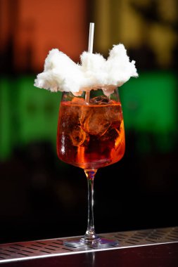 Arka planda koyu mavi ve mor renkli bulanık bir karışım var. Bu da modern bir bar ya da dinlenme odası atmosferi olduğunu gösteriyor.