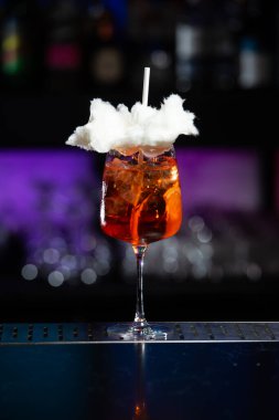 Arka planda koyu mavi ve mor renkli bulanık bir karışım var. Bu da modern bir bar ya da dinlenme odası atmosferi olduğunu gösteriyor.