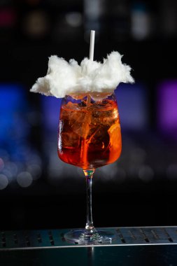 Arka planda koyu mavi ve mor renkli bulanık bir karışım var. Bu da modern bir bar ya da dinlenme odası atmosferi olduğunu gösteriyor.