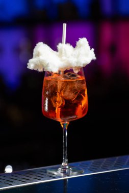 Arka planda koyu mavi ve mor renkli bulanık bir karışım var. Bu da modern bir bar ya da dinlenme odası atmosferi olduğunu gösteriyor.