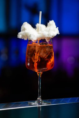 Arka planda koyu mavi ve mor renkli bulanık bir karışım var. Bu da modern bir bar ya da dinlenme odası atmosferi olduğunu gösteriyor.