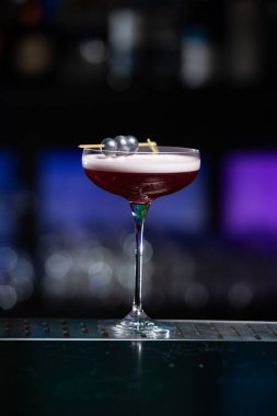 Bulanık arka planda yeşil ve beyaz Bokeh ışıkları ipuçları içeren koyu tonlar var. Bu da şık bir bar ayarına işaret ediyor.