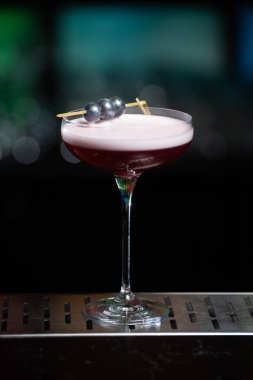 Bulanık arka planda yeşil ve beyaz Bokeh ışıkları ipuçları içeren koyu tonlar var. Bu da şık bir bar ayarına işaret ediyor.