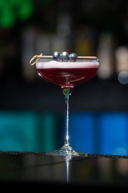 Bulanık arka planda yeşil ve beyaz Bokeh ışıkları ipuçları içeren koyu tonlar var. Bu da şık bir bar ayarına işaret ediyor.