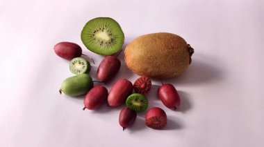 Aktinidia arguta Kens Kırmızı ve yeşil Rogow mini kivi küçük ve büyük kivi meyveleri beyaz arka planda kapalı tam HD