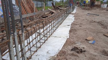 İşçiler beton temel için metal takviyesi yapıyorlar