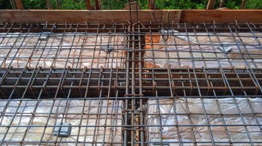 Döşeme döşemeleri inşaat halinde. İşçiler, beton dökülmeden önce keresteye çelik takviyesi yapmakla meşguldü.