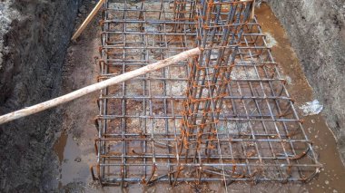 İnşaat işçileri inşaat alanında çelik takviye çubuğu üretiyorlar.